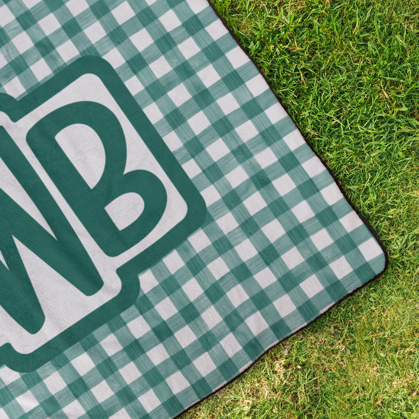 Gingham_Monogram_Blanket_StadiumBlanket_OverheadGrass_H_Mockup.png